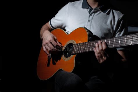 Man Playing An Acoustic Guitar On A Dark Background Playing Guitar