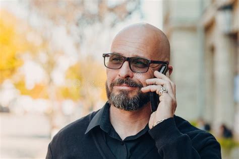 outdoor portrait of a 50 year old happy man wearing a black shirt and glasses stock image