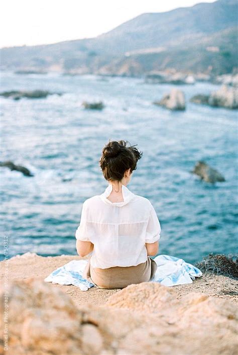 Woman Sitting On Seaside Cliff By Stocksy Contributor Daniel Kim
