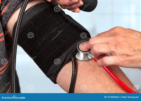 Doctor Measures The Blood Pressure With Stethoscope Stock Image Image