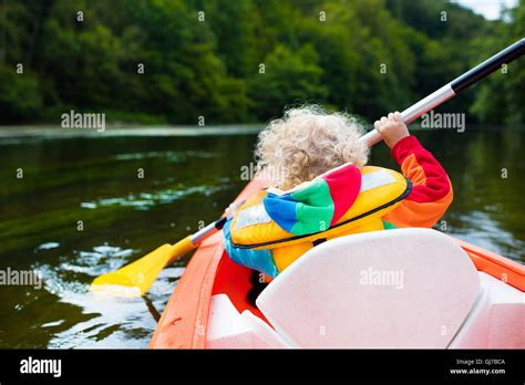 Happy Kid Enjoying Kayak Ride On Beautiful River Little Curly Toddler