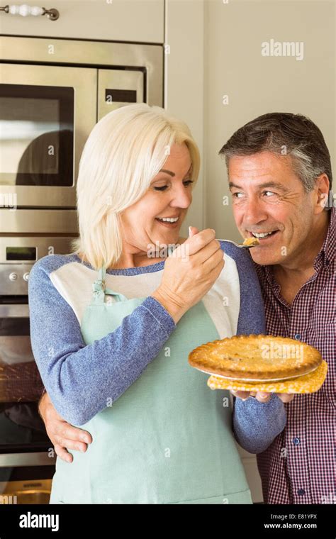 Happy Mature Blonde Feeding Pie To Husband Stock Photo Alamy