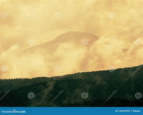 Distant Mountain Range And Heavy Clouds Of Colorful Mist Above Deep