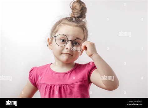 Clever Little Surprised Girl In Trendy Pink Dress Posing To The Camera