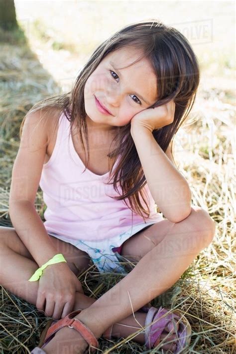 Portrait Of Girl Sitting On Grass In Park Stock Photo Dissolve