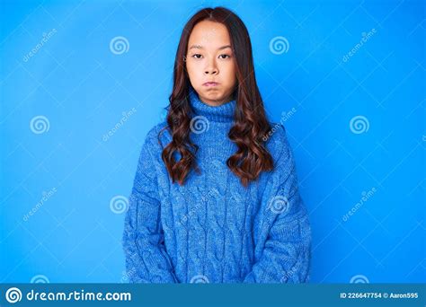 Young Beautiful Chinese Girl Wearing Casual Winter Sweater Puffing