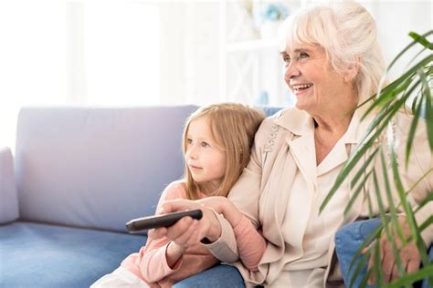 Girl And Grandma Watching Tv Free Photo