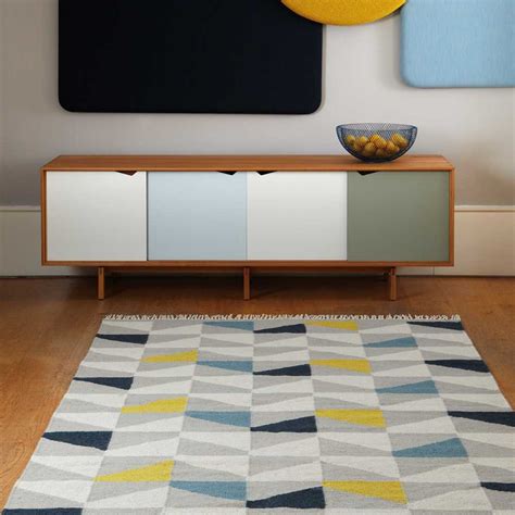 Il est composé de laine et est tissé à la main. Tapis design type kilim tissé main gris jaune et bleu