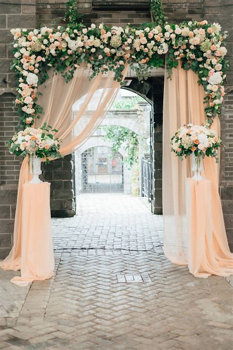 Wedding Ceremony Flower Arch With A Light Peach Colored Fabric