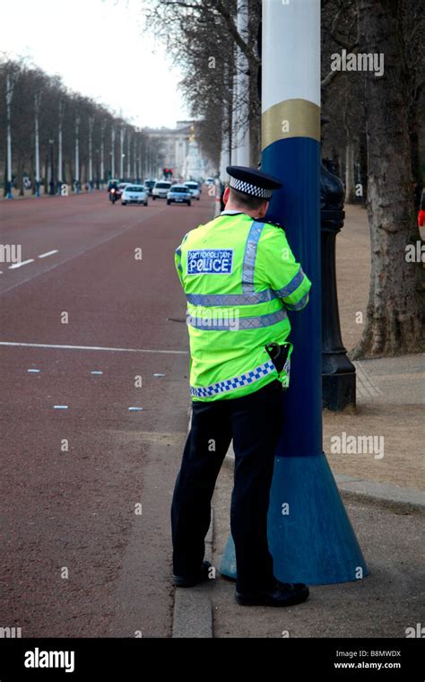 A Male Police Officer Using A Speeding Gun On The Mall In London Mar