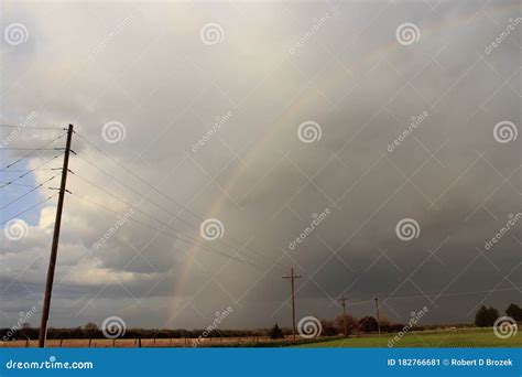 Colorful Kansas Rainbow With Clouds And Powerlines Out In The Country