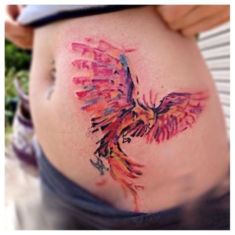 A Womans Stomach With A Colorful Bird Tattoo On It