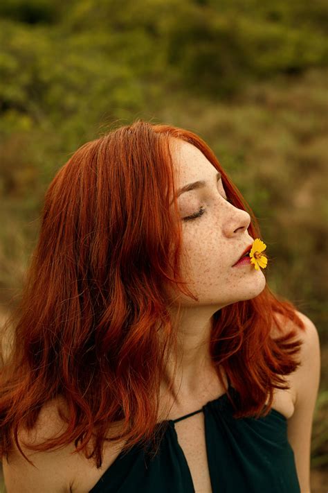 Photo Of Red Haired Woman With Yellow Petaled Flower On Her Lips · Free