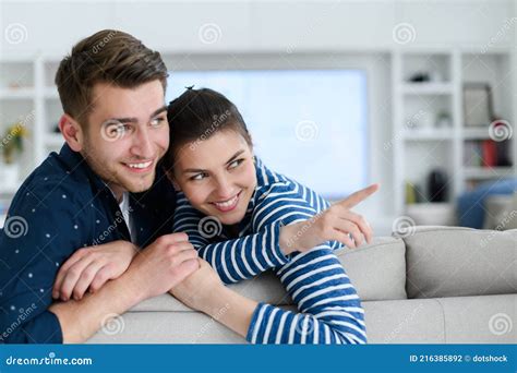 A Young Married Couple Enjoys Sitting In The Large Living Room Stock