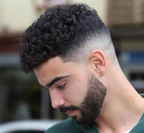 homme cheveux bouclés brun avec coupe dégradé haut et haut plus épais