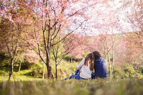 Premium Photo Young Couple Walking In The Park And Looking Cherry