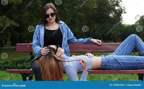 Lesbian Girlfriends Lie On Bench In The Park Two Lesbians Woman Hugs And Laugh Stock Footage