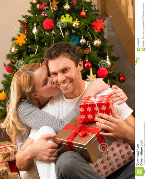 Senior couple together at seaside. Young Couple With Gifts In Front Of Christmas Tree Stock ...