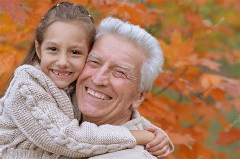 Premium Photo Grandfather And Granddaughter In Park