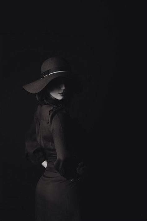 A Black And White Photo Of A Mannequin Wearing A Hat In The Dark