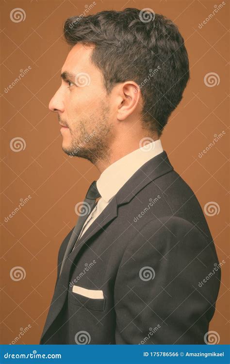 Young Handsome Hispanic Businessman Against Brown Background Stock