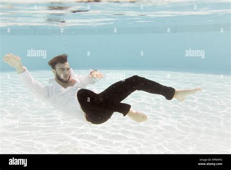 A Young Man Floating Underwater While Fully Clothed Stock Photo Alamy
