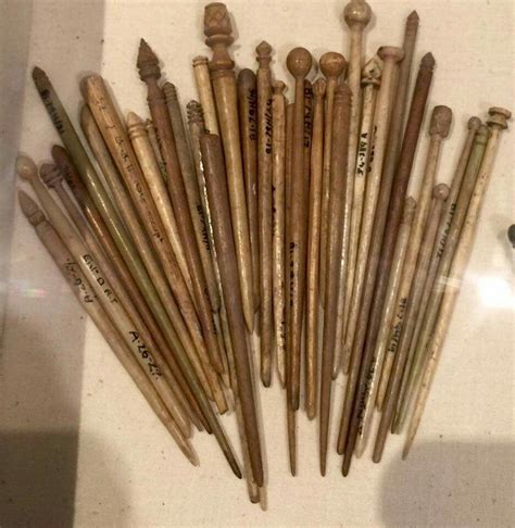 Several Wooden Crochet Hooks Are Lined Up In A Row On A Counter Top