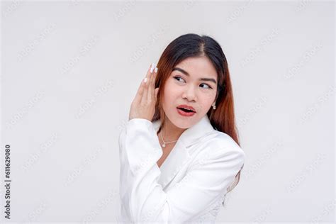 An Intrigued Young Woman Listening Carefully With One Hand On Her Ear