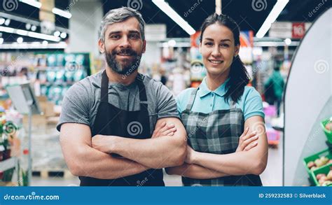 Portrait of Two Supermarket Employees Attractive People in Aprons