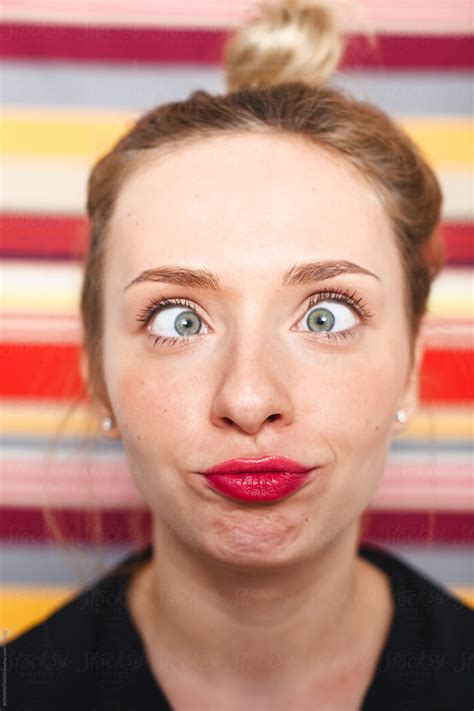 Blonde Woman Making Funny Faces In Front Of A Striped Wall By Stocksy Contributor