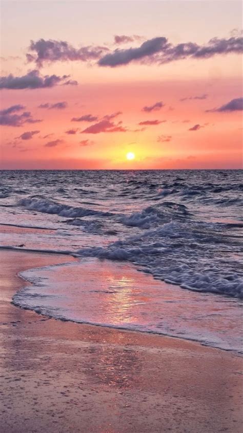 Calm Ocean Waves Rolling To Shore As The Sun Sets Beach Sunset
