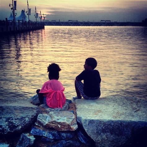 Brother And Sister Soaking Up The Beauty Of A Golden Sunset At The