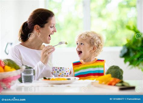 Niño Que Introduce De La Madre La Mamá Alimenta Verduras Del Niño