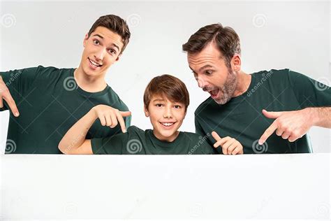 Dad And His Two Sons Pointing On An Empty White Board Smiling Studio