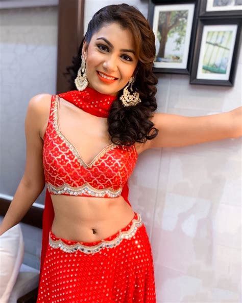 A Woman In A Red Belly Dance Outfit Posing For The Camera With Her Hand On Her Hip