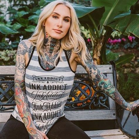 a woman with tattoos sitting on a bench