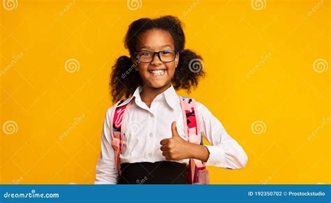 Cheerful Black School Girl Gesturing Thumbs Up Posing Over Yellow