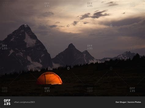 An Orange Tent Lit By Headlamps With The Selkirk Mountains And Mount