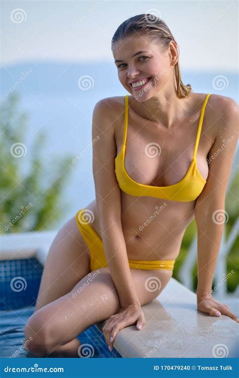 Woman In Bikini On The Sun Tanned Slim And Shapely Body Is Posing Near