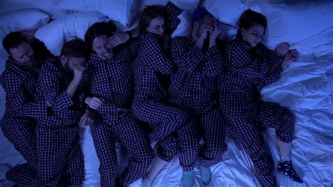 Five Women In Matching Pajamas Are Sleeping On A Bed With White Sheets And Blue Lights