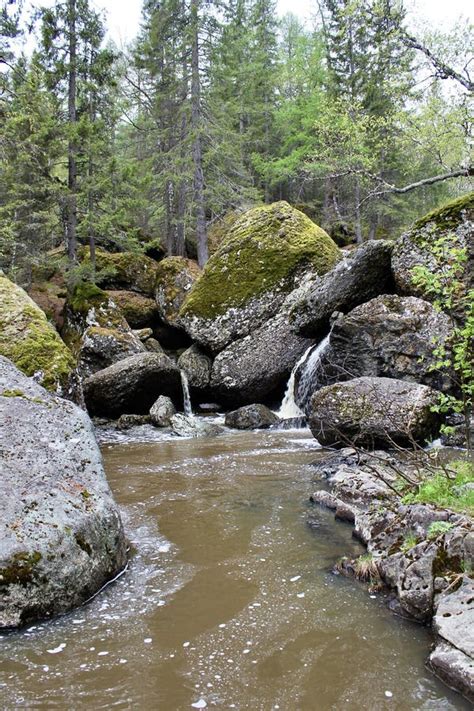 A Mountain River Waterfall Flows Through A River Bed Through Huge