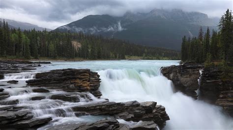 Waterfall River With Landscape Of Fog Mountains In Alberta Athabasca