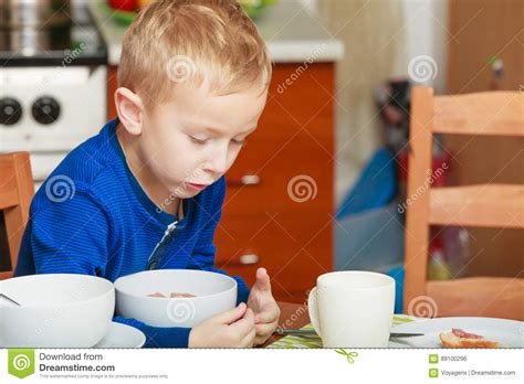 Kid Boy Eating Breakfast Cereals And Milk In Bowl Stock Photo Image