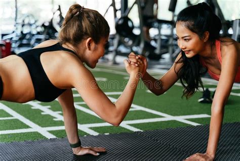 Healthy Smiling Female Supportive Friends Giving High Five To Each Other While Pushing Up In The