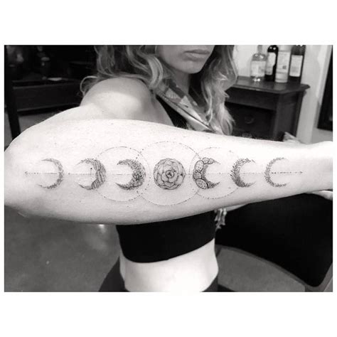 Next, we have an amazing moon phase tattoo with a wolf design. Fine line moon phases made out of plants.