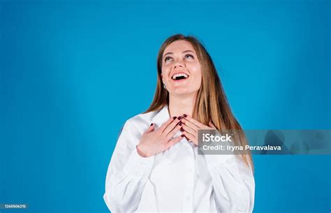 American Woman Smiling As She Tilts Her Head Back To Look Into The Air Isolated On A Blue