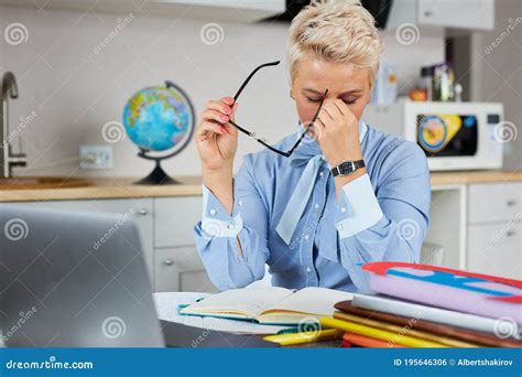 Tired Stressed Young Teacher Woman Sitting At Her Desk With Books In