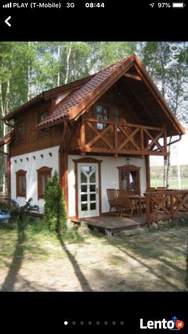 * salon, a w nim narożnik z funkcją spania 140x200 cm z pościelą, stół z krzesłami, ława kawona, piec. Archiwalne Domki letniskowe nad jeziorem Kaszuby Bory ...