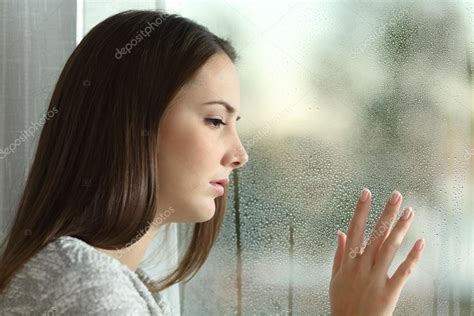 Sad Woman Looking Rain Through A Window Stock Photo By ©antonioguillemf