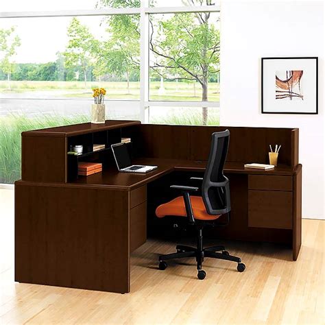 The prepositions at and on give different meanings. HON 10700 Series Reception Desk - Premium Veneer Casegoods